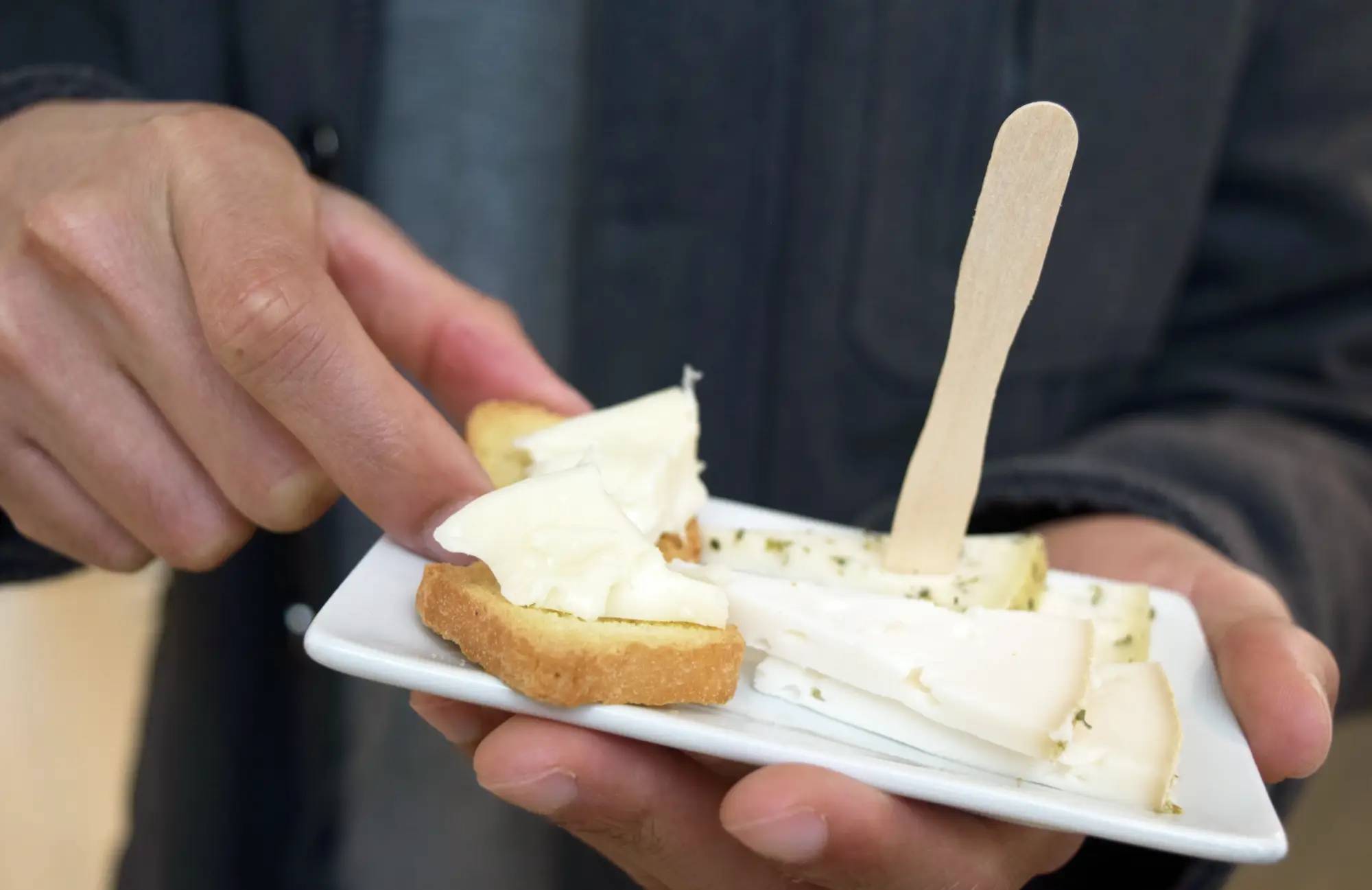 Someone holding various cheeses